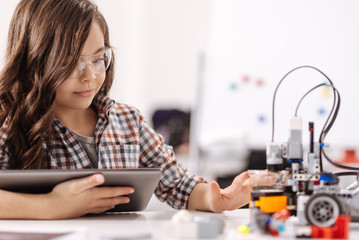 Charismatic teen girl using devices in the science studio