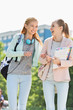 © MDBPIXS - Cheerful young female college students walking in campus