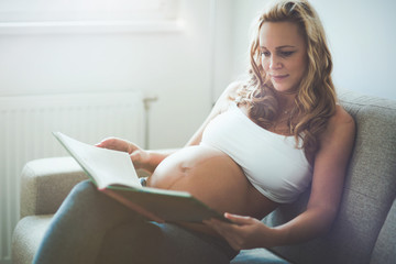 Wall Mural - Beautiful pregnant woman reading book