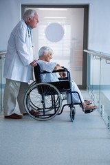 Wall Mural - Doctor and senior patient on wheelchair in the passageway