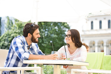 Wall Mural - Smiling couple having mojito at sidewalk cafe