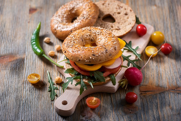 Wall Mural - Vegetarian bagel sandwich with fresh veggies and arugula salad, healthy vegan snack