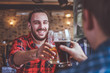 © Karanov images - Two bearded hipsters clinking glasses of beer at bar. Cheers.