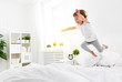 happy child girl  jumps and plays bed