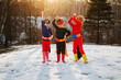 © RooM The Agency - Three children wearing superhero costumes standing side by side on a frozen lake in winter, USA