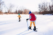© RooM The Agency - Rear view of boys skiing on snowy landscape