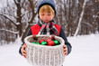 © RooM The Agency - Close up of boy holding Christmas decorations in snow