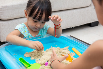 Wall Mural - Asian Chinese little girl playing kinetic sand at home