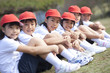 © amanaimages - Elementary school children sitting on grass looking at camera, Japan
