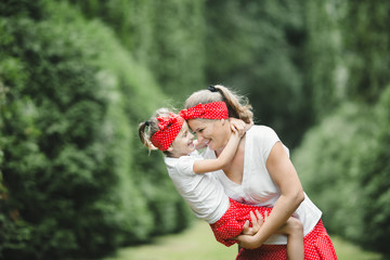 Wall Mural - Mother swings her little daughter holding her in the arms