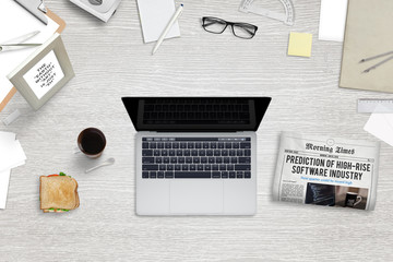 Poster - Break in office with sandwich, tea and newspaper. Office supplies and stationery beside. Top view. Laptop with blank screen for mockup.