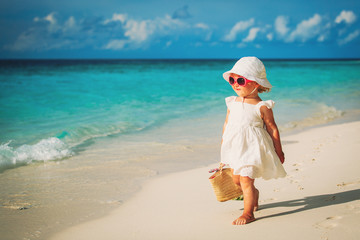 Wall Mural - happy cute little girl walk on sand beach