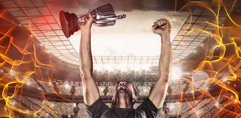 Poster - Composite image of happy rugby player holding trophy