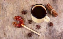 Black Coffee And Spices In A Mug Enamelling And A Lollipop In The Shape Of A Rooster. Coffee, Spices And Sweets