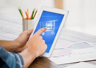 Poster - Man touching shopping cart icon on digital tablet