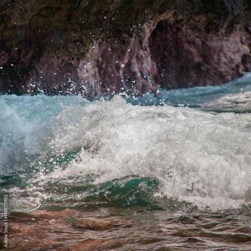 Ocean Waves Splach On The Background Of Rocks In The Bay - 