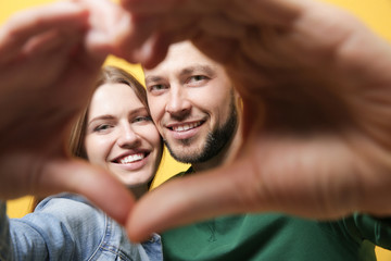 Canvas Print - Happy young couple making heart with their hands, closeup