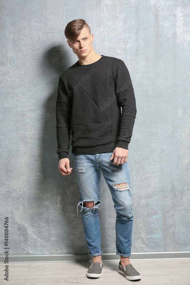 Handsome young man near textured wall