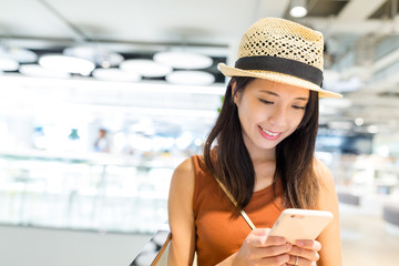 Wall Mural - Woman using cellphone in shopping mall