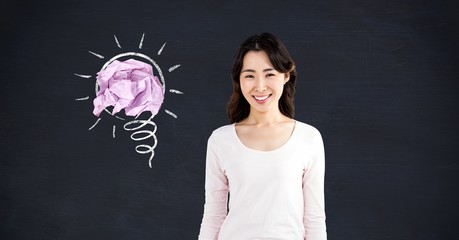 Canvas Print - Woman standing next to light bulb with crumpled paper