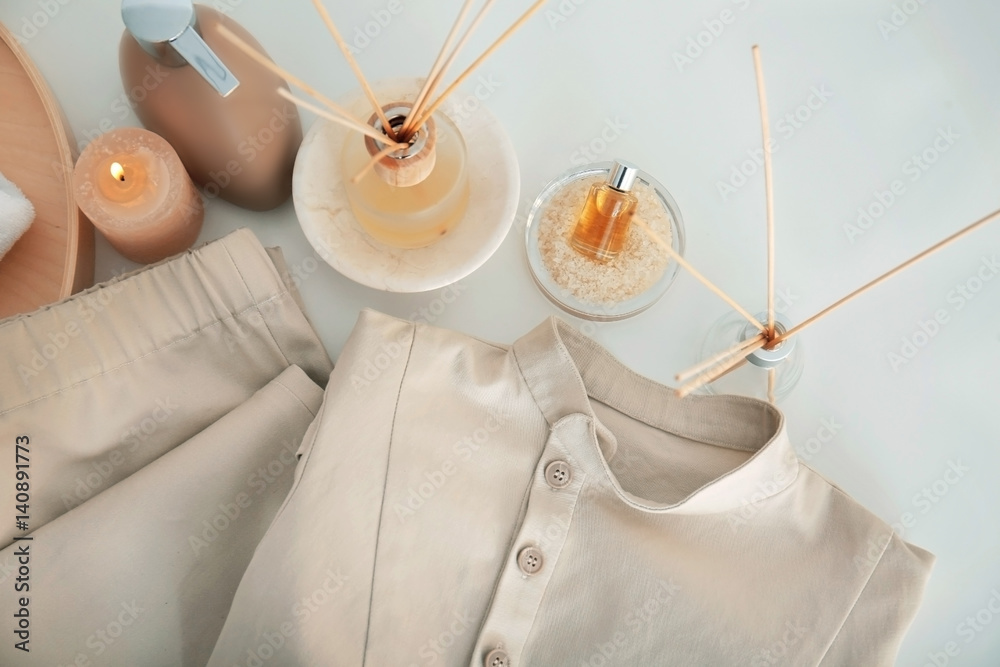 Spa uniform and supplies of masseur on light background