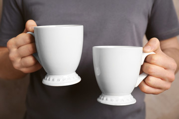 Sticker - Blank white cups in hands, closeup