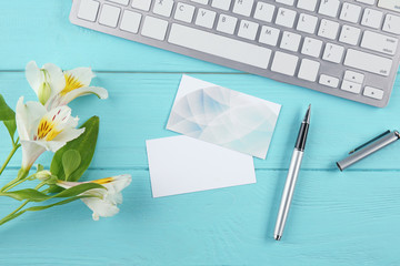 Computer and business cards on blue wooden desk, flat lay