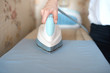 © sata_production - Woman tailor ironing textile with steaming on the iron board before starting work
