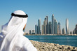 Modern buildings in Dubai Marina,, UAE. Man in Arab dress looks at the city