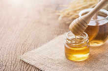 Honey With Wooden Honey Dipper On Wooden Table