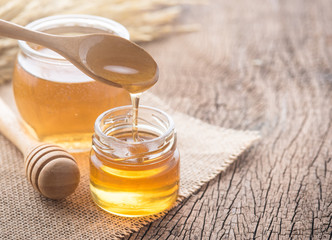 Wall Mural - honey with wooden honey dipper on wooden table