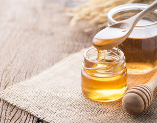 Wall Mural - honey with wooden honey dipper on wooden table