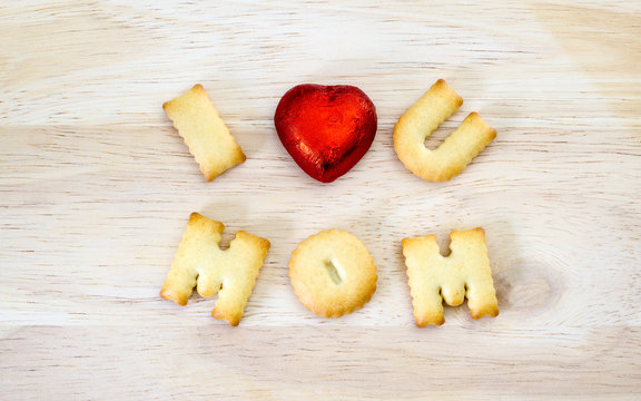 Mother's day Greeting card concept. I love you mom. Text from the salty crackers as printed English letters that lie on a wooden background. Top view.