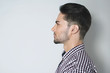 © Nik Stock Studio - Side view of handsome young man. Beautiful profile of brunette man in checkered shirt against light grey background