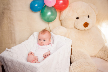 A small baby girl is photographed in a beautiful dress for 4 months