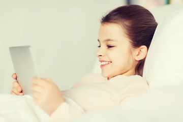 Poster - happy girl lying in bed with tablet pc at home