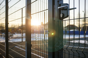 entrance to the playground of fence and the wicket of the welded wire mesh green color with a metal lock and handle