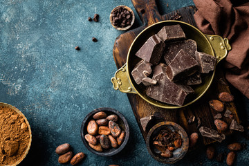 Dark chocolate pieces crushed and cocoa beans, culinary background, top view