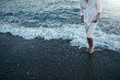 Attractive cropped man body wearing white shirt and pants on the beach and sea outdoor background, front view. Travel vacation holiday. Man walking barefoot in the sea at sunset on the background.
