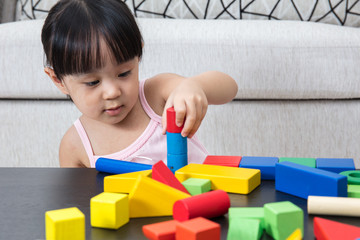 Wall Mural - Asian Chinese little girl playing building blocks at home