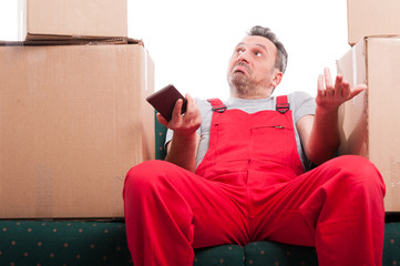 mover man sitting on couch holding phone and gesturing