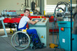 disabled worker in wheelchair in factory and colleague