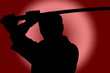 Silhouette of man with sword on red background