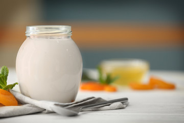 Wall Mural - Glass jar with tasty yogurt on wooden table