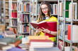 © rh2010 - Young happy and enthusiastic female student reading books at the old library