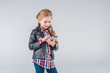 © LIGHTFIELD STUDIOS - Adorable smiling little girl using smartphone on grey