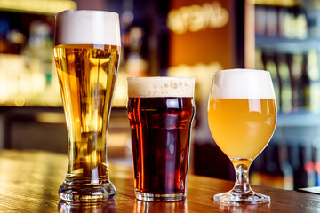 Glass of light and dark beer on a pub with bokeh background