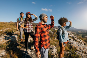 Wall Mural - group of hiking friends enjoying the view from mountain peak