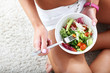Young woman eating healthy salad after workout