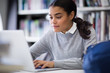 © ReeldealHD images - Student working on laptop in library